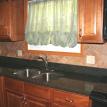 Granite top with tumbled marble herring bone tile back splash.