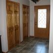 Front foyer with tile floor and pine raised panel by-fold doors.