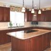 Juparana granite counter top on cherry cabinets lit up by pendent lights